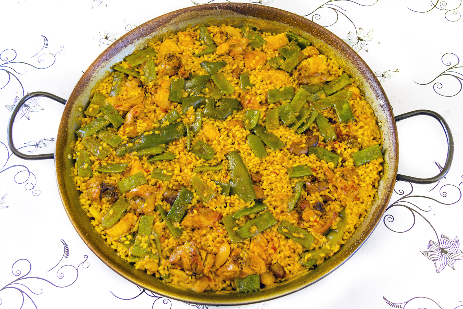 Traditional paella valenciana with rabbit, chicken, ferraura, and garrofón — no seafood. Photo by Jan Harenburg, CC BY-SA 4.0, via Wikimedia Commons.