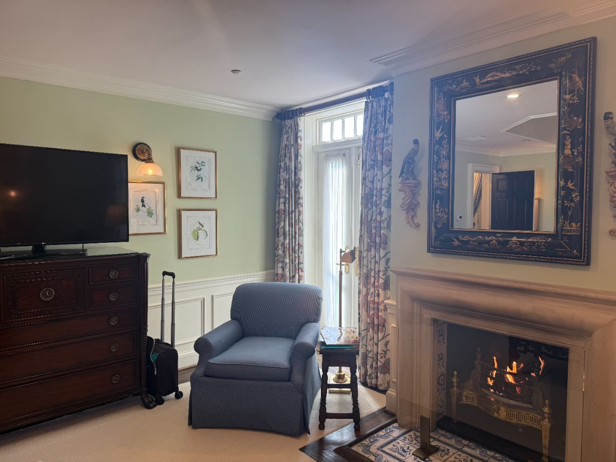 A sitting area with a working fireplace and a chinoiserie mirror above the mantel.